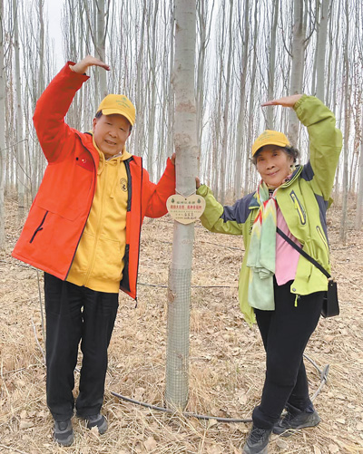 今年3月，李德仁（左）和朱宜萱在生态林合影。受访者供图