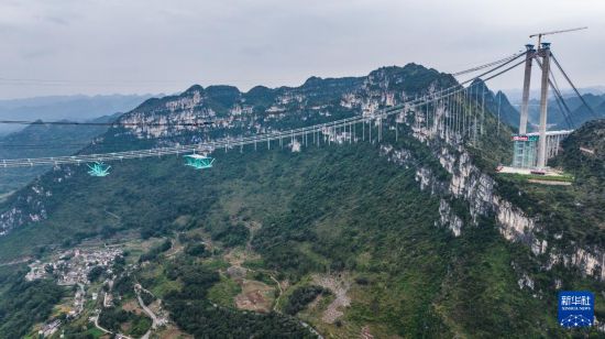 花江峡谷大桥的首件钢桁梁在吊装运输中（11月4日摄，无人机照片）。新华社记者 陶亮 摄